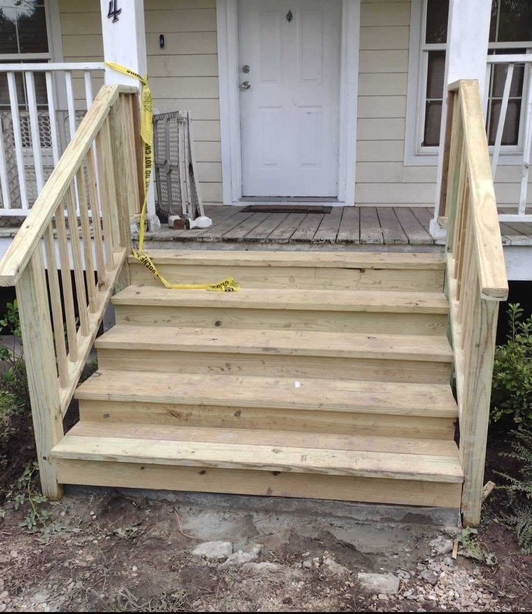New pressure-treated entry steps and handrails built at a front porch