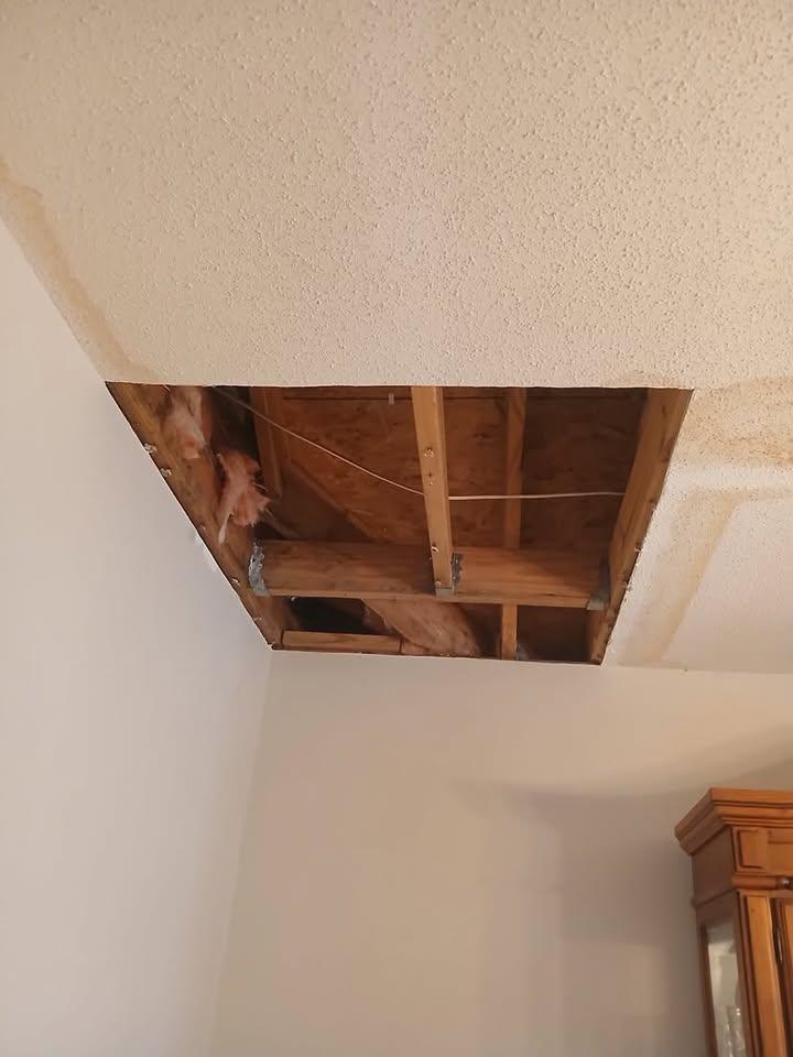 Brown water staining spread across a textured ceiling near a wall corner