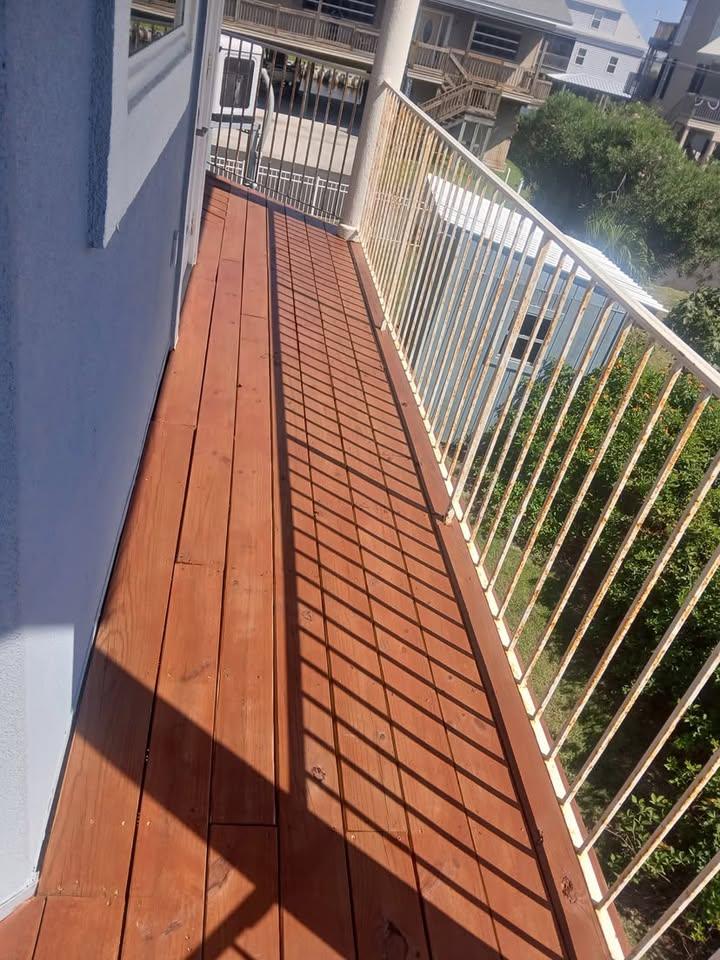 Narrow deck walkway refinished alongside a white metal railing