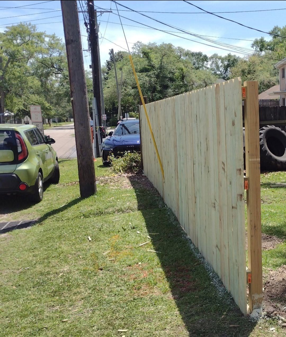 Pressure-treated privacy fence with exposed post detail along a street frontage